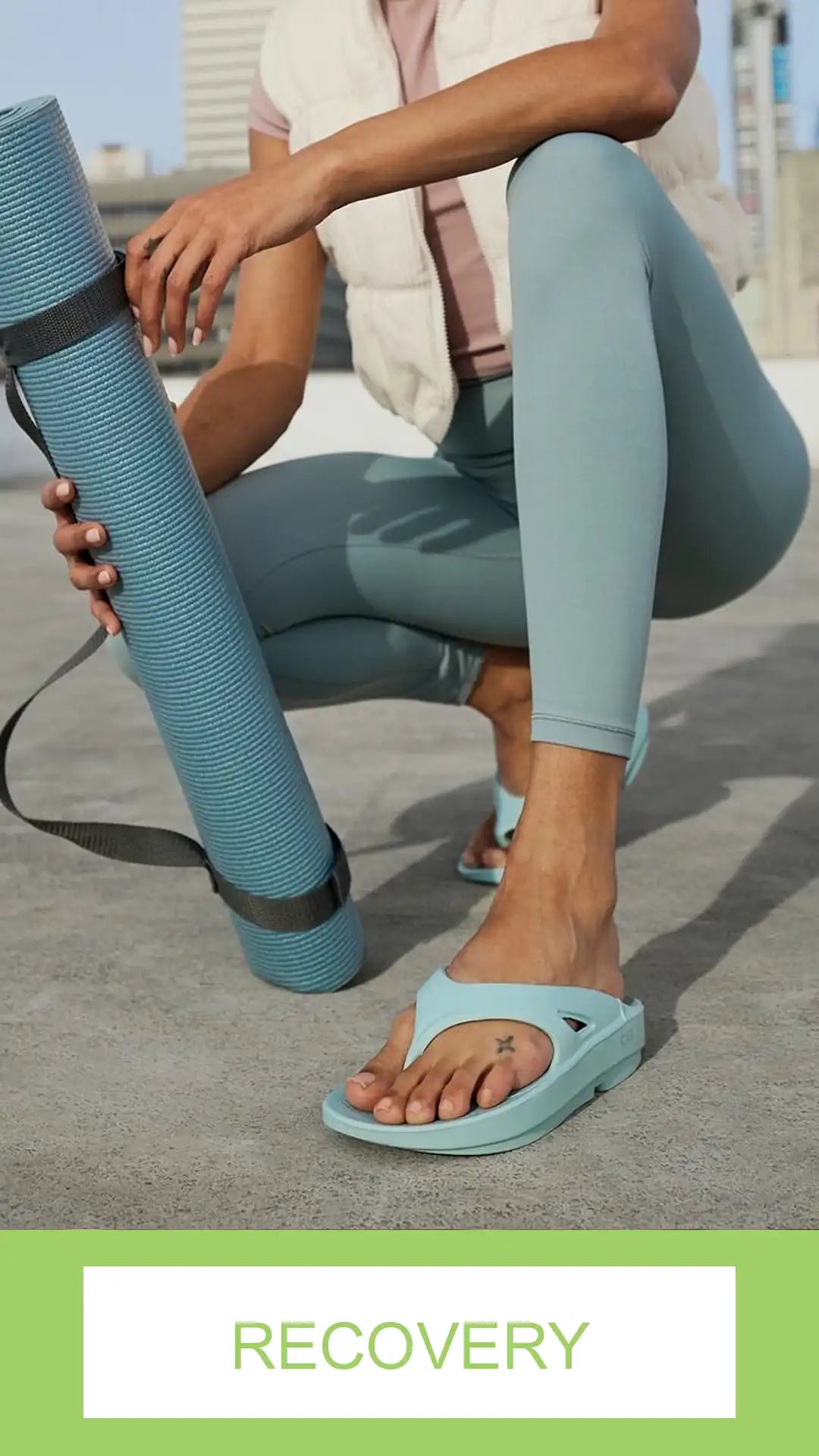 Person in teal leggings and sandals holding a yoga mat with 'Recovery' text at the bottom.