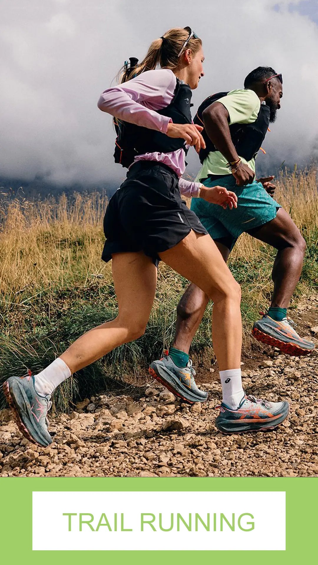 Two runners on a trail with a mountainous background